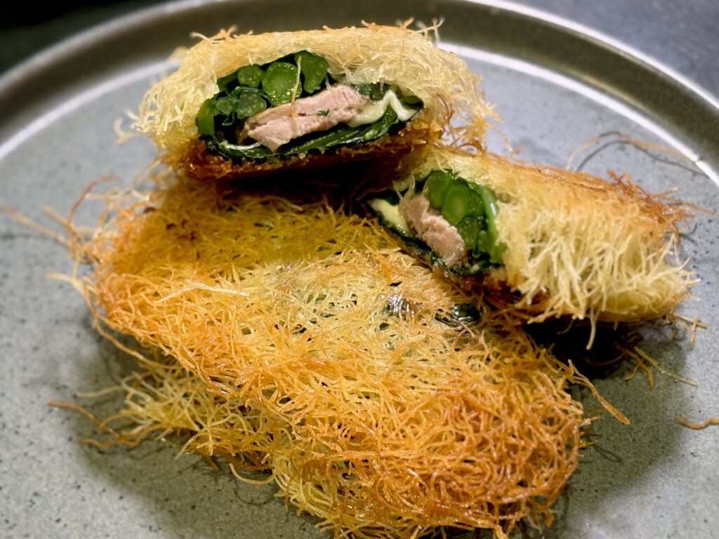 ケールで巻いた仔牛とモッツァレラのロールをカダイフで包み焼きにし、バーニャカウダソースで食べる料理