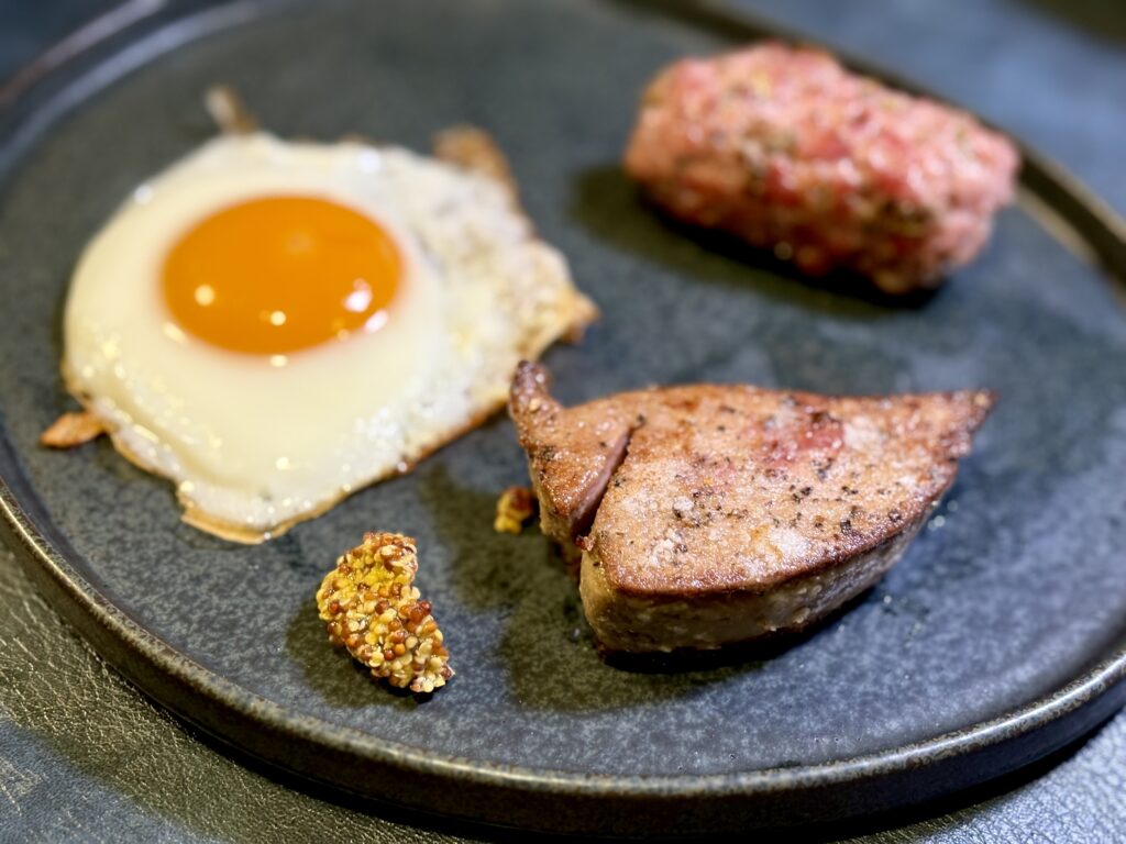 豚レバーステーキとサルシッチャと目玉焼きのプレート