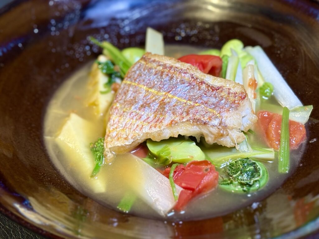 皮目をパリッと焼いたイトヨリ鯛と春野菜、アメーラトマトの骨出汁スープ仕立て