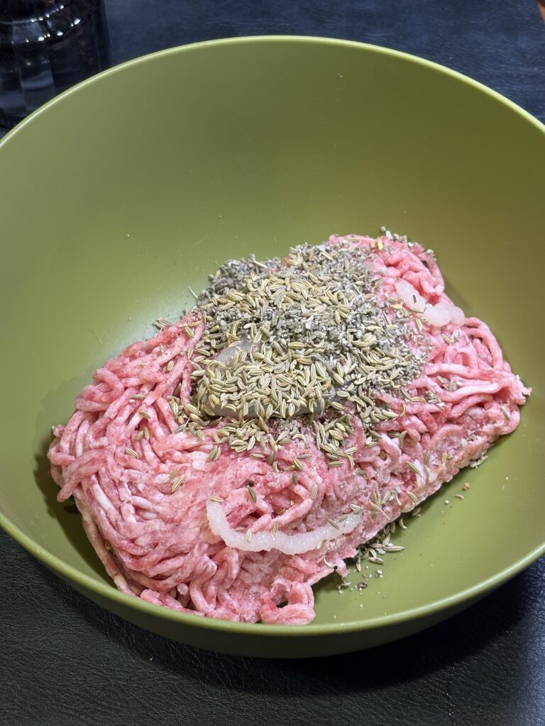 豚ひき肉にフェンネルとセージ、にんにく、塩、胡椒を合わせた自家製サルシッチャの仕込み写真