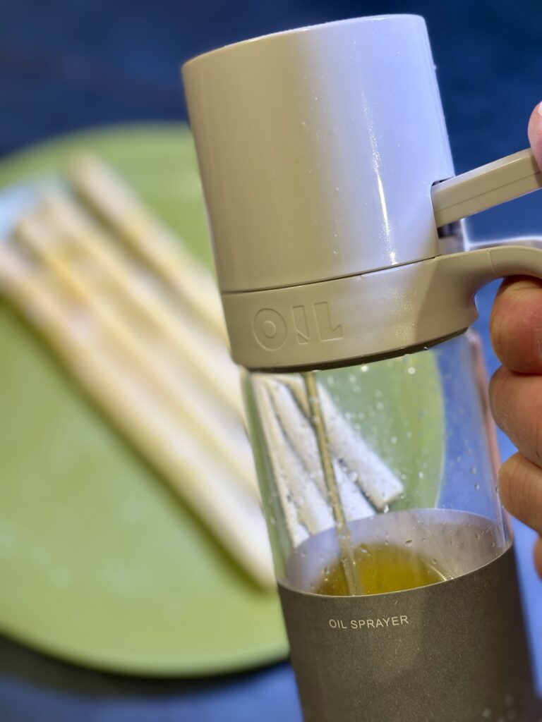 ホワイトアスパラにオリーブオイルをスプレーする工程