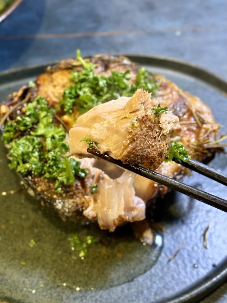 焼いたマグロのテールの身を箸でほぐしているアップ写真