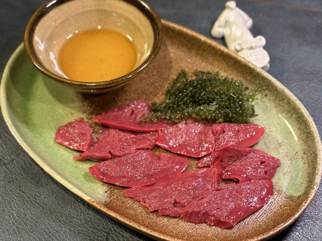 モウカの星 毛鹿鮫のハツを薄切りにして海ぶどうと即席ごまダレで盛り付けた刺身風の一皿