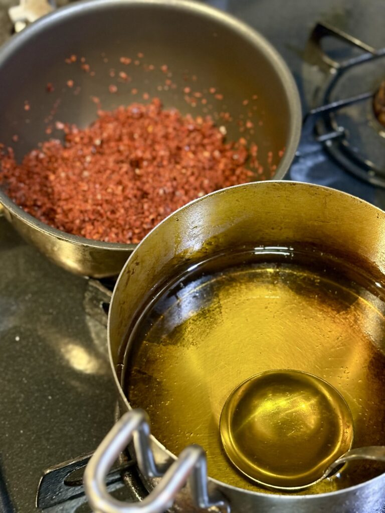 唐辛子粉を入れた鍋と香味油を用意して自家製辣油を作る準備写真
