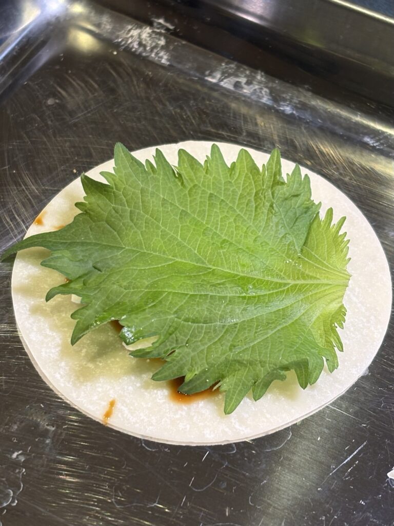 オイスターソースとチーズの上に大葉をのせた餃子の皮
