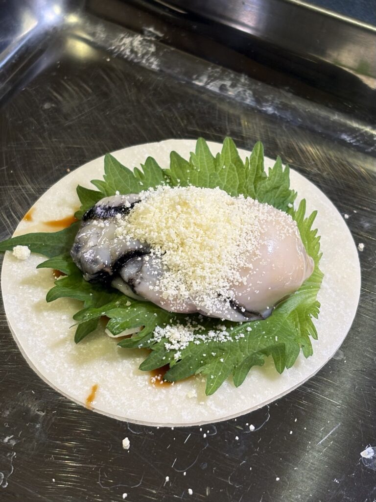 牡蠣の上に粉チーズをふった餃子