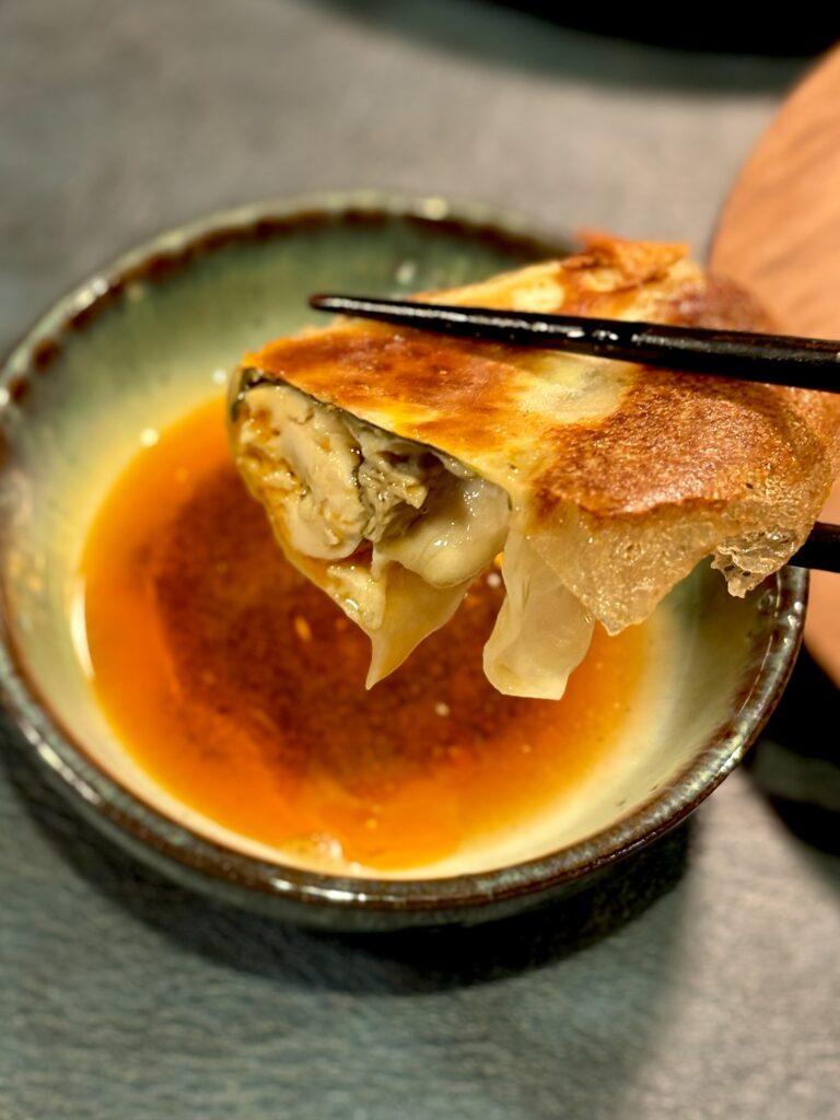 自家製辣油と酢のたれにつけた牡蠣餃子