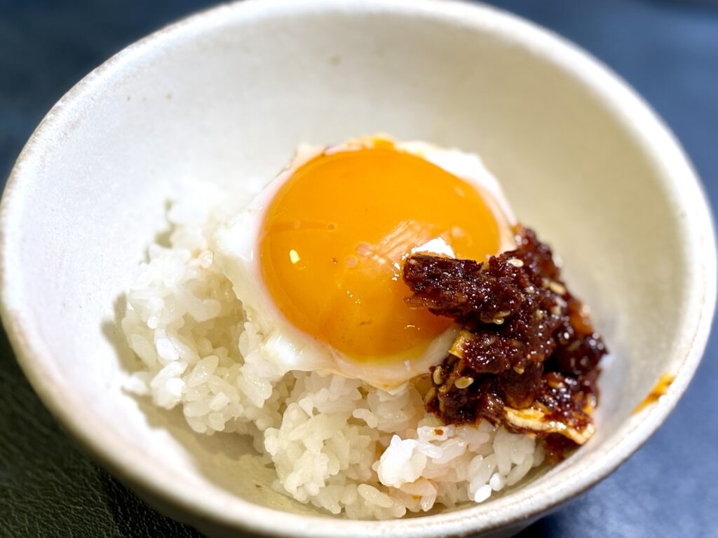 白ごはんに半熟目玉焼きと食べる辣油をのせた朝ごはん