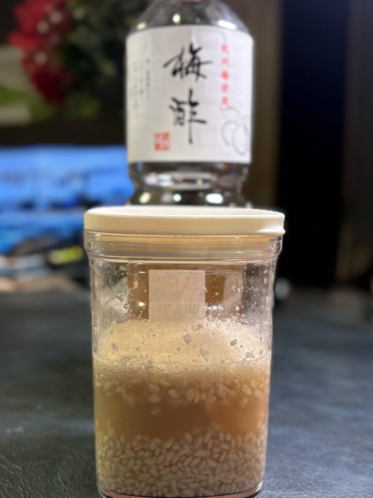 梅酢と米麹を容器に入れて梅酢麹を仕込んでいる写真