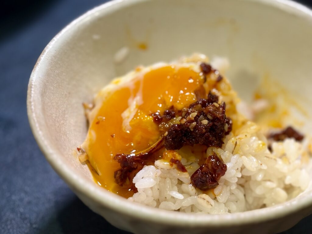 半熟目玉焼きの黄身を崩し食べる辣油をごはんに絡めた朝ごはん