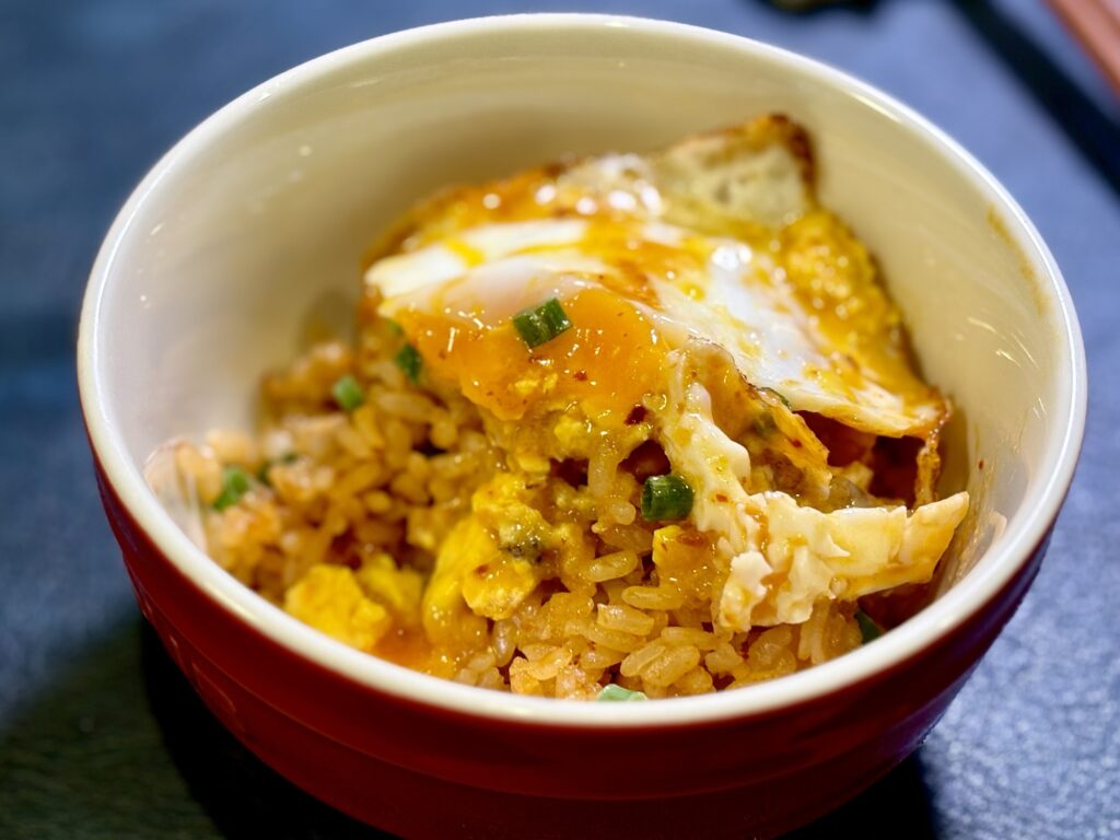 麻辣湯ブイヤベースのパエリア風ごはんに目玉焼きをのせた写真
