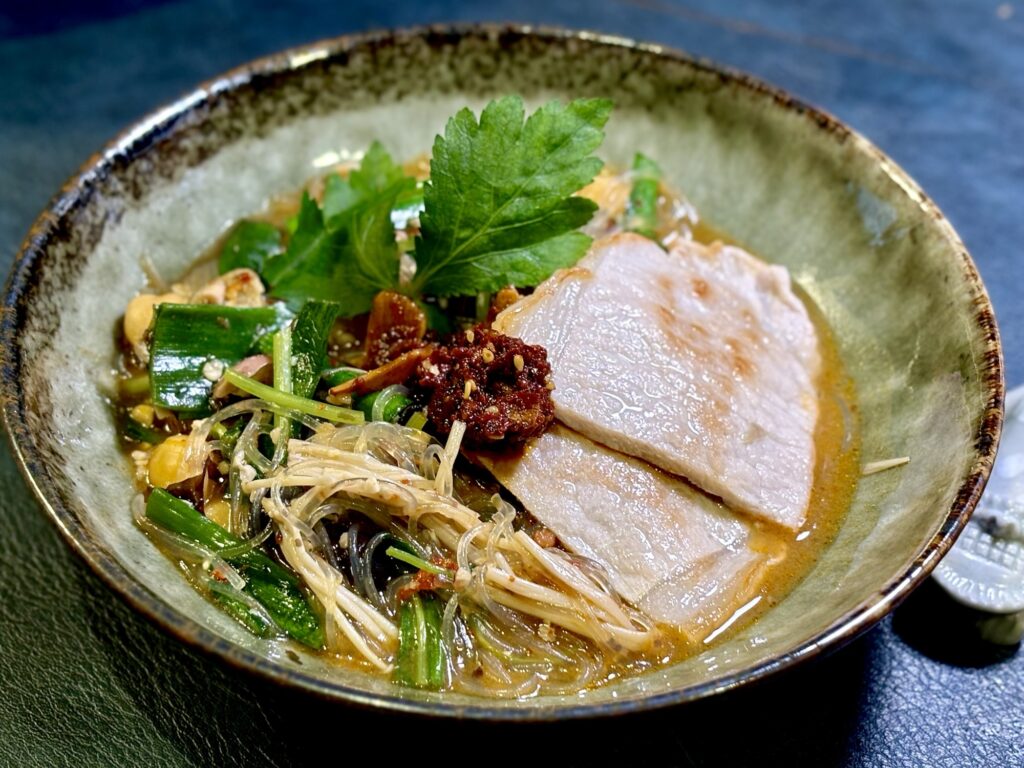 焼いた豚ロース肉と食べる辣油をのせた黒豆麹味噌入り麻辣湯