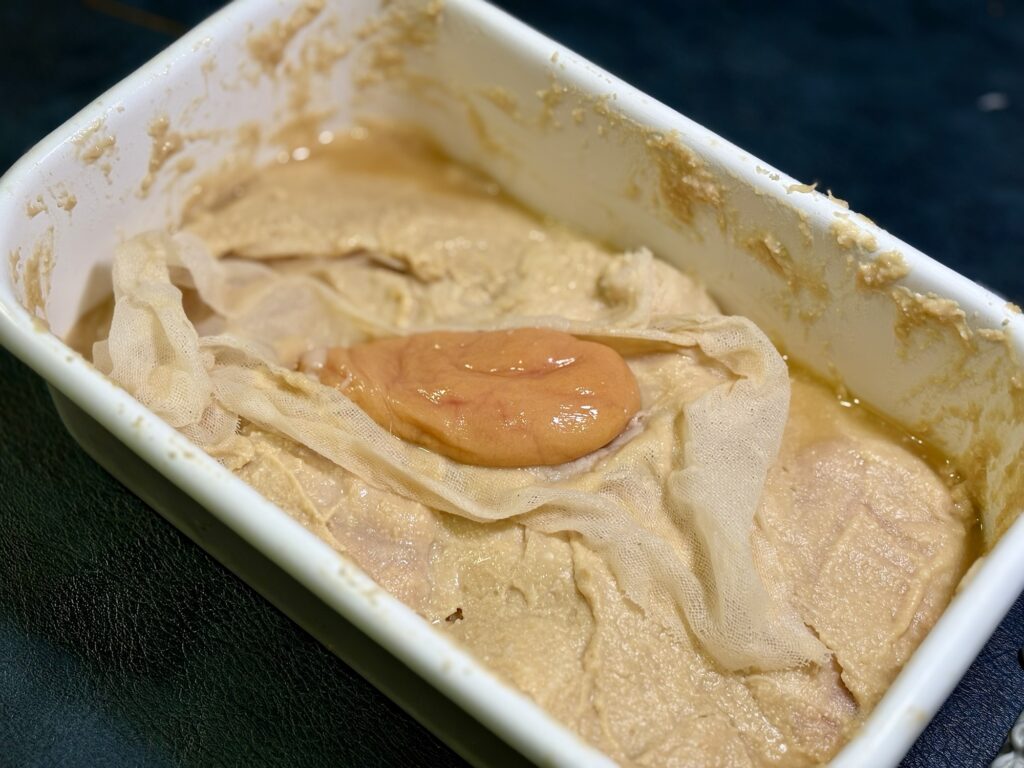 真鯛の魚卵を西京味噌床に漬けている様子