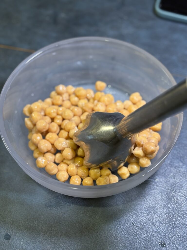 蒸しひよこ豆をハンドブレンダーでつぶしているところ