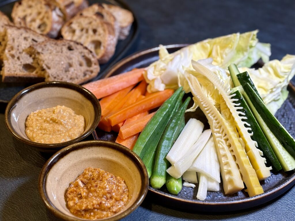 ひよこ豆味噌と食べる辣油味噌ディップを生野菜とパンに添えた前菜プレート