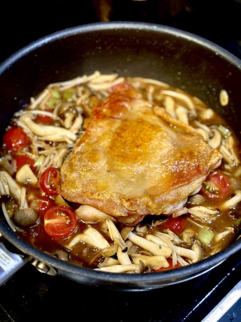 皮パリに焼いた鶏もも肉をオイスターソースと黒酢の中華風ソースに戻す様子