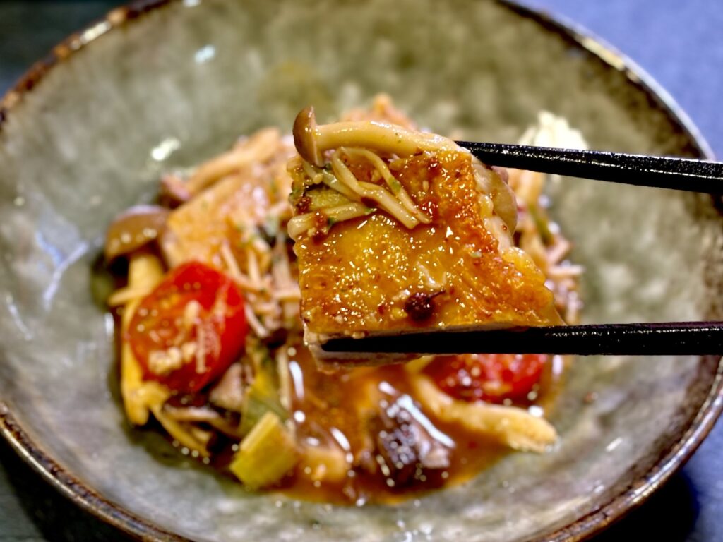 箸で持ち上げた皮パリ鶏もも肉ときのこの中華風カチャトーラ
