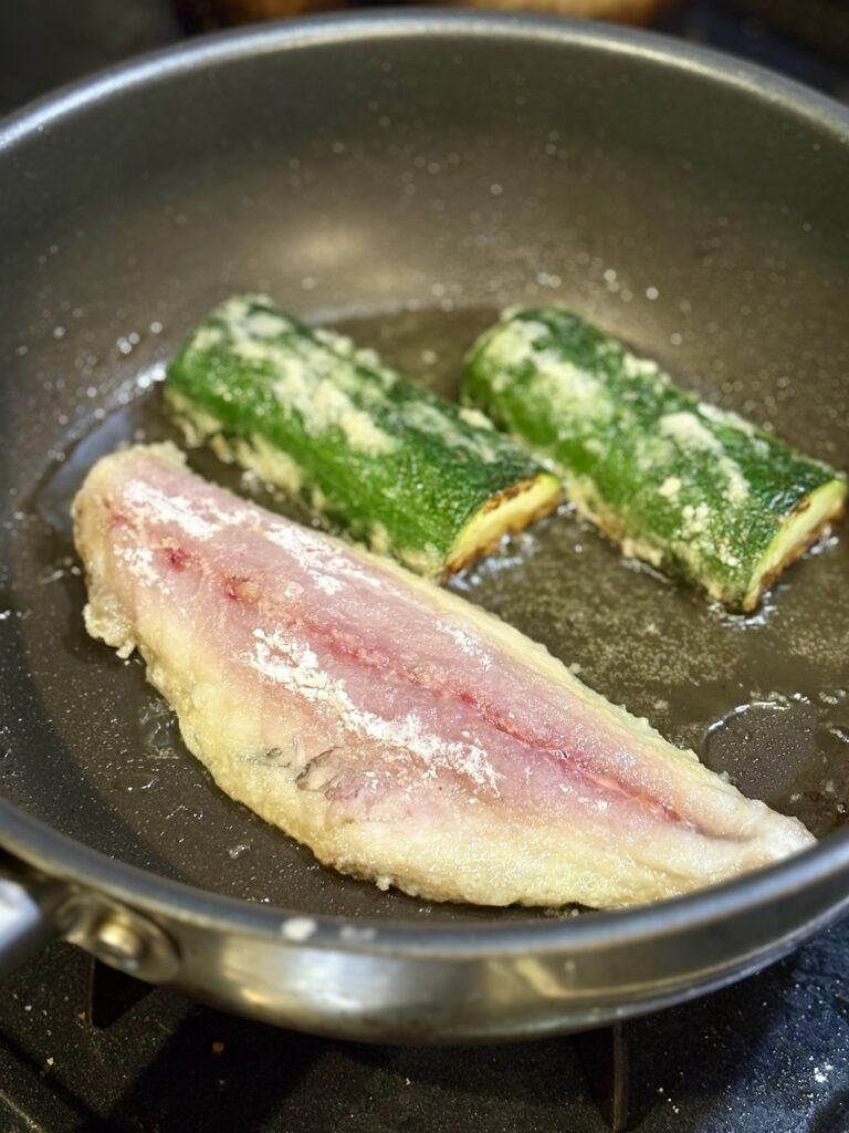 フライパンでアジとズッキーニを焼いている様子
