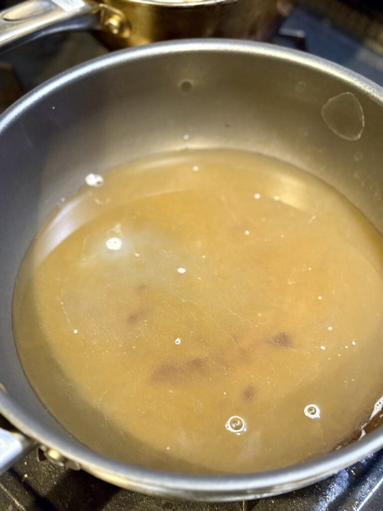 オイスターソース入りのスープでリゾットのベースを作る様子