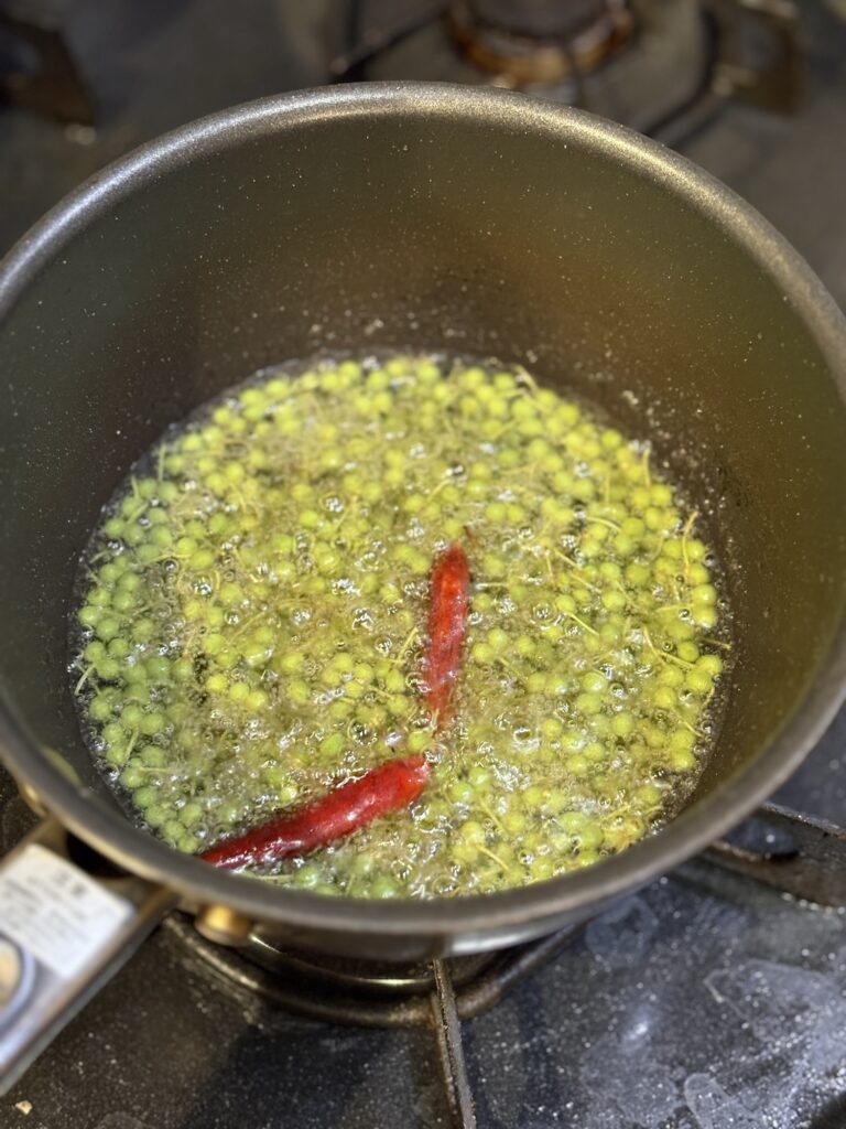 アンチョビ太白胡麻油に山椒の実を加える