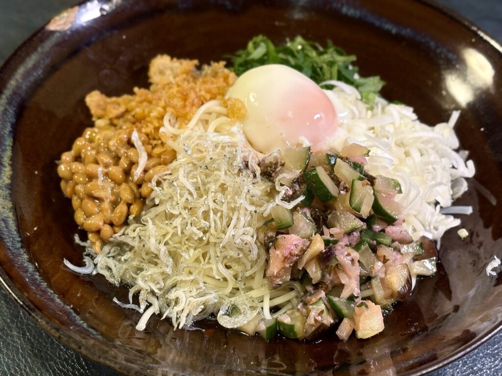 赤紫蘇麹しば漬けと納豆、温泉たまごを盛り付けた半田そうめんの和え冷麺