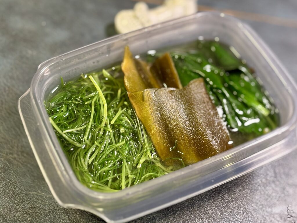 透明醤油の出汁に浸かったおかわかめとおかひじきと昆布