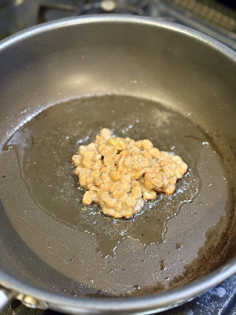 フライパンで納豆を油で焼き香ばしさを出している様子