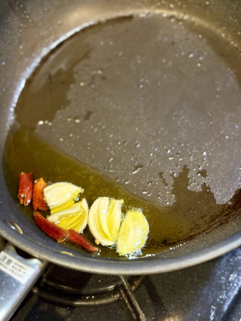 オリーブオイルでにんにくと唐辛子を炒める