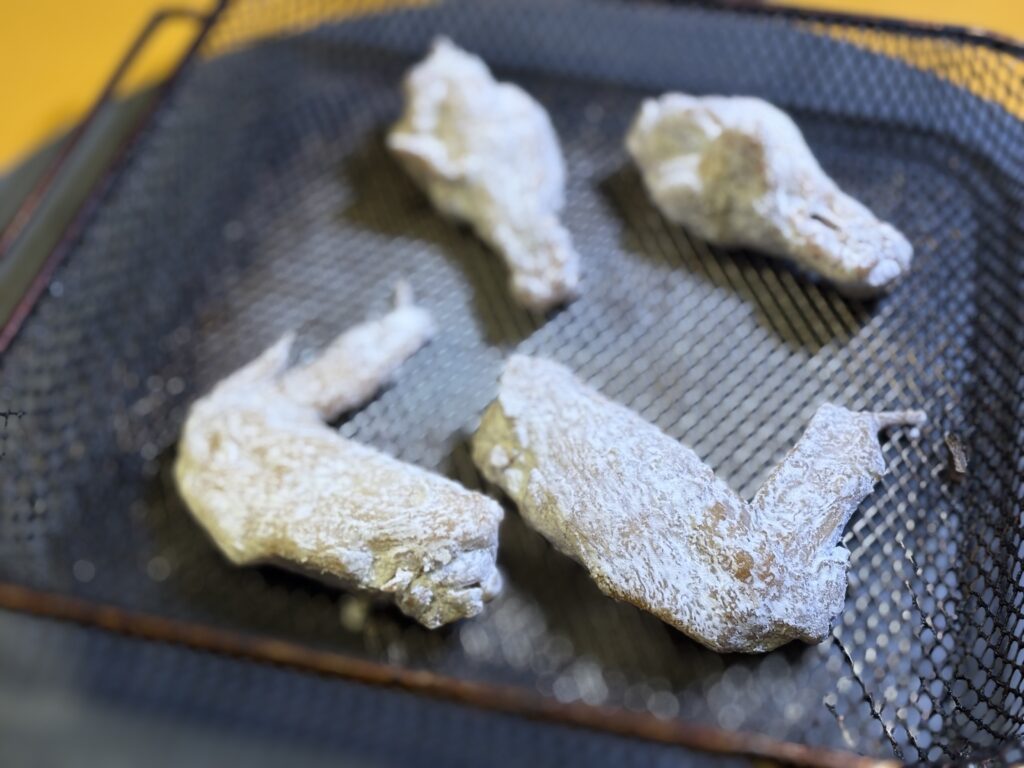 粉を振って揚げる手羽唐揚げ
