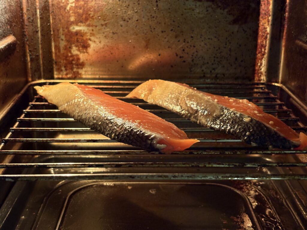 ンフライオーブンの網に銀鮭の切り身をのせて焼いている様子(西京焼き)