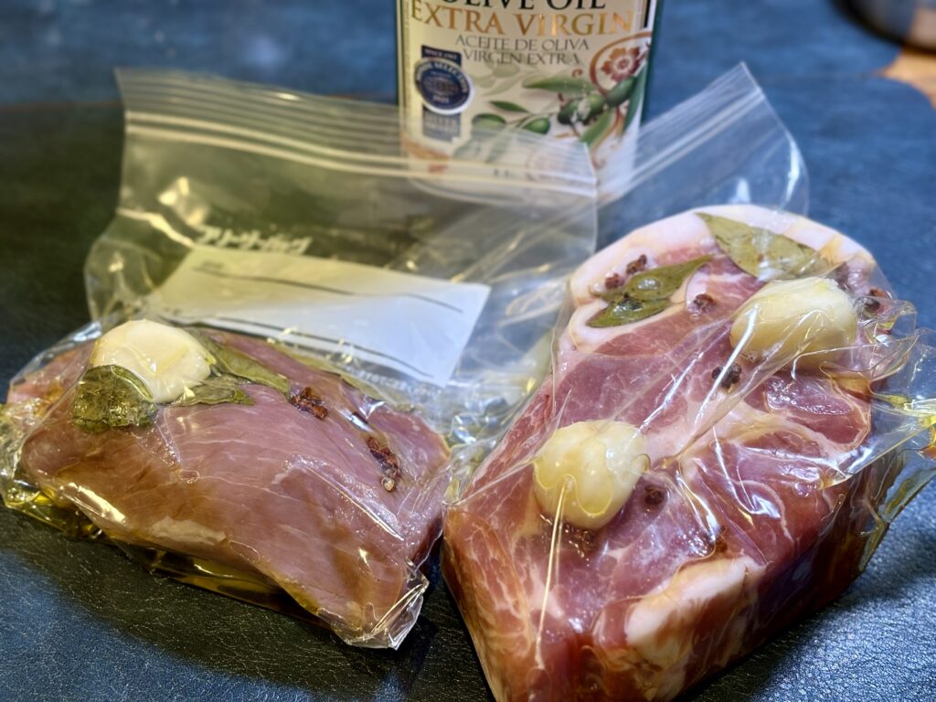 オリーブオイルとハーブで下味を付けた肉の真空調理準備。低温調理前の仕込み工程
