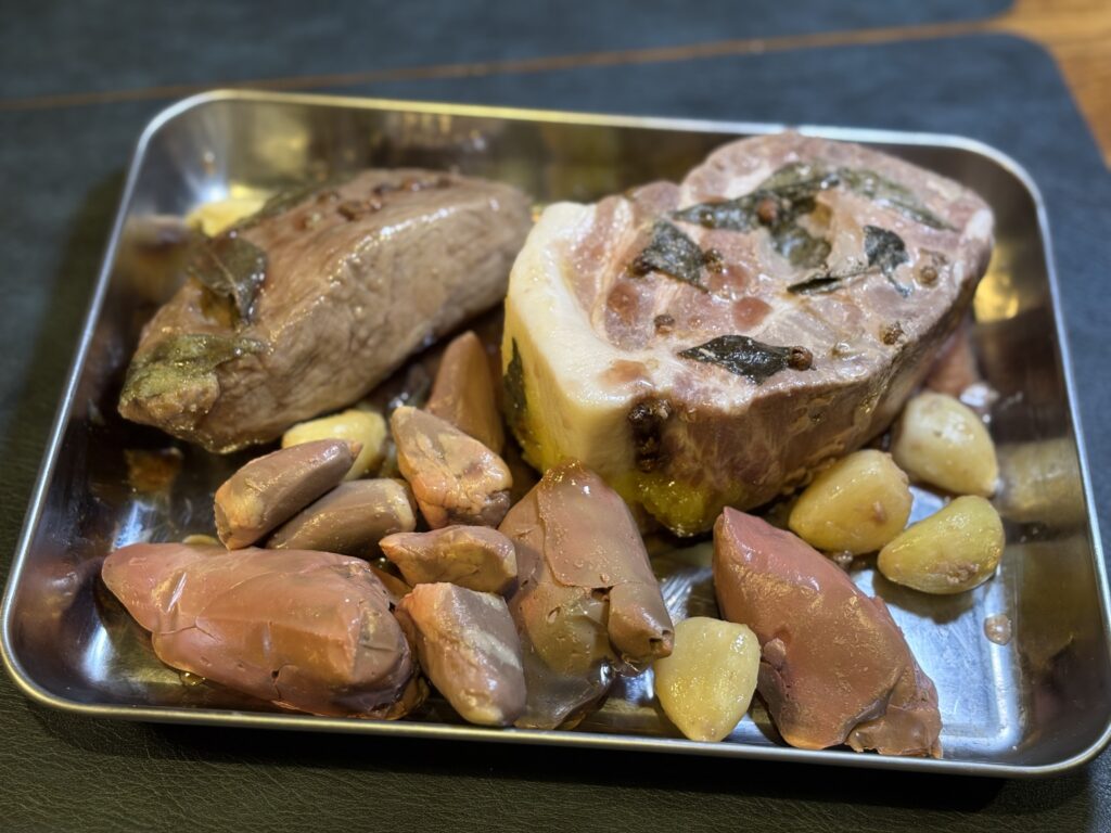 低温調理した豚肉とレバーの下処理状態。にんにくとハーブで火入れしたカツレツ用素材
