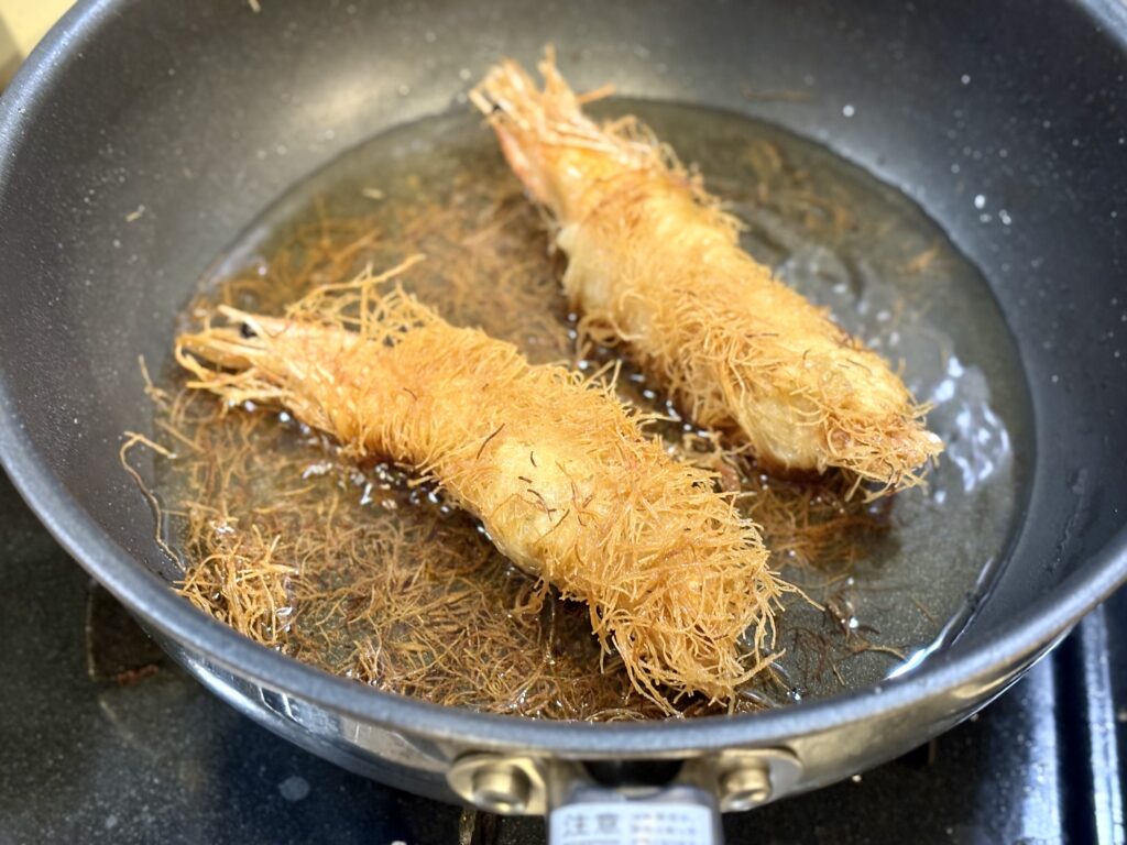 天使の海老のカダイフ包みをフライパンで揚げ焼きしている様子
