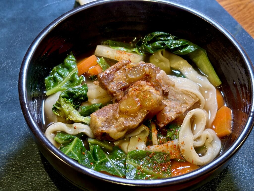 やわらかケールと根菜のソーキほうとう　ソーキと野菜のだしにケールを加えた仕上がり