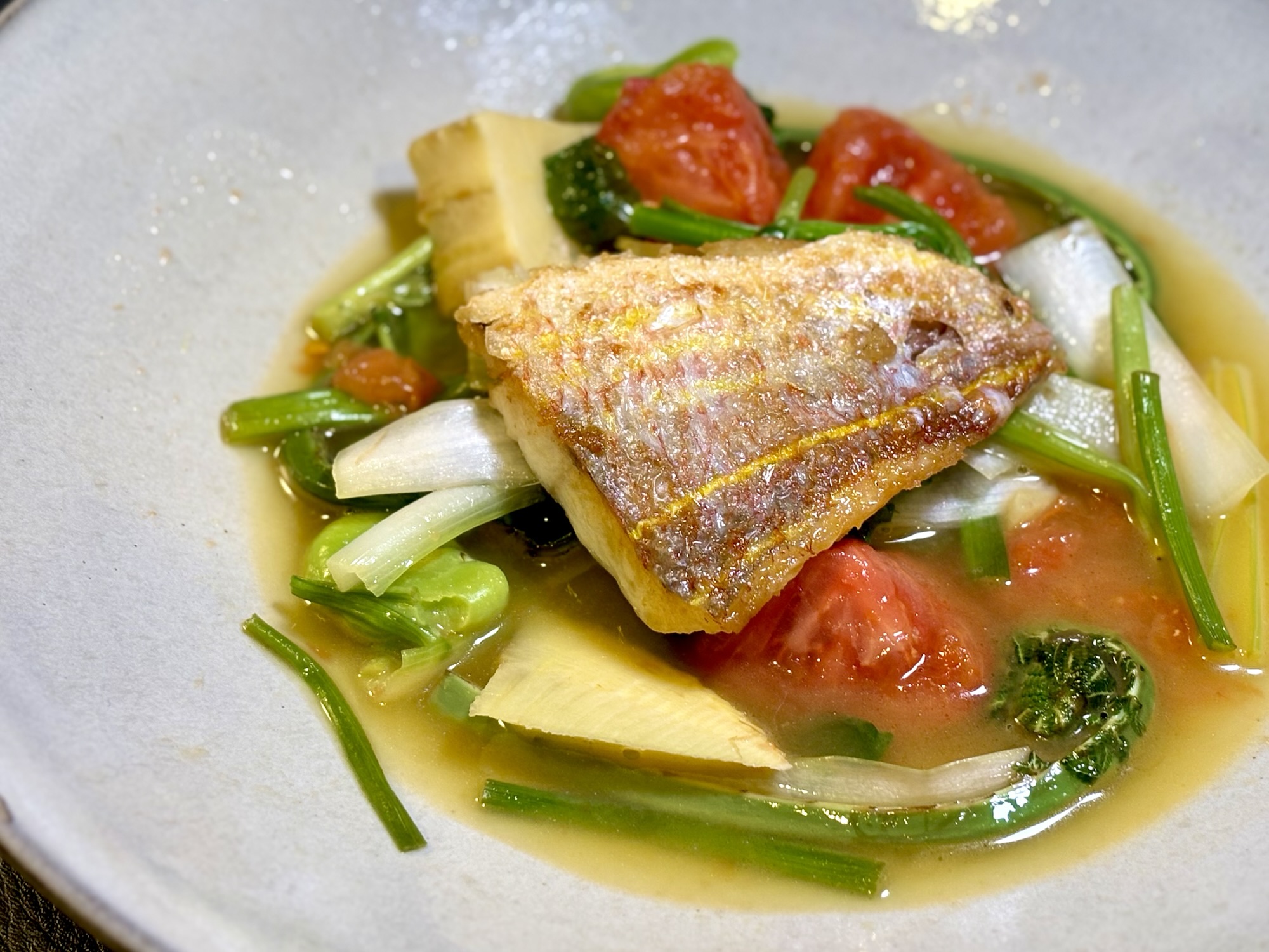 イトヨリ鯛と春野菜（タケノコ、うるい、菜花、そら豆）を使った骨出汁スープのプリマヴェーラ