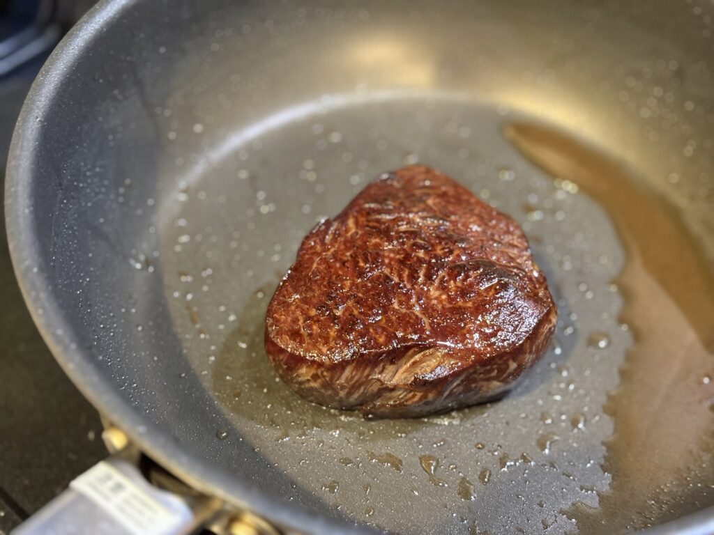 ステーキに発酵バターを加える仕上げ