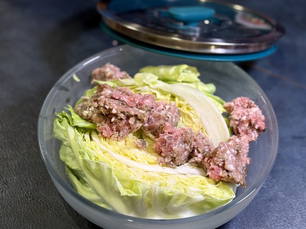 春キャベツのくし切りと新玉ねぎ、生の自家製サルシッチャをエニディに入れた調理前の写真