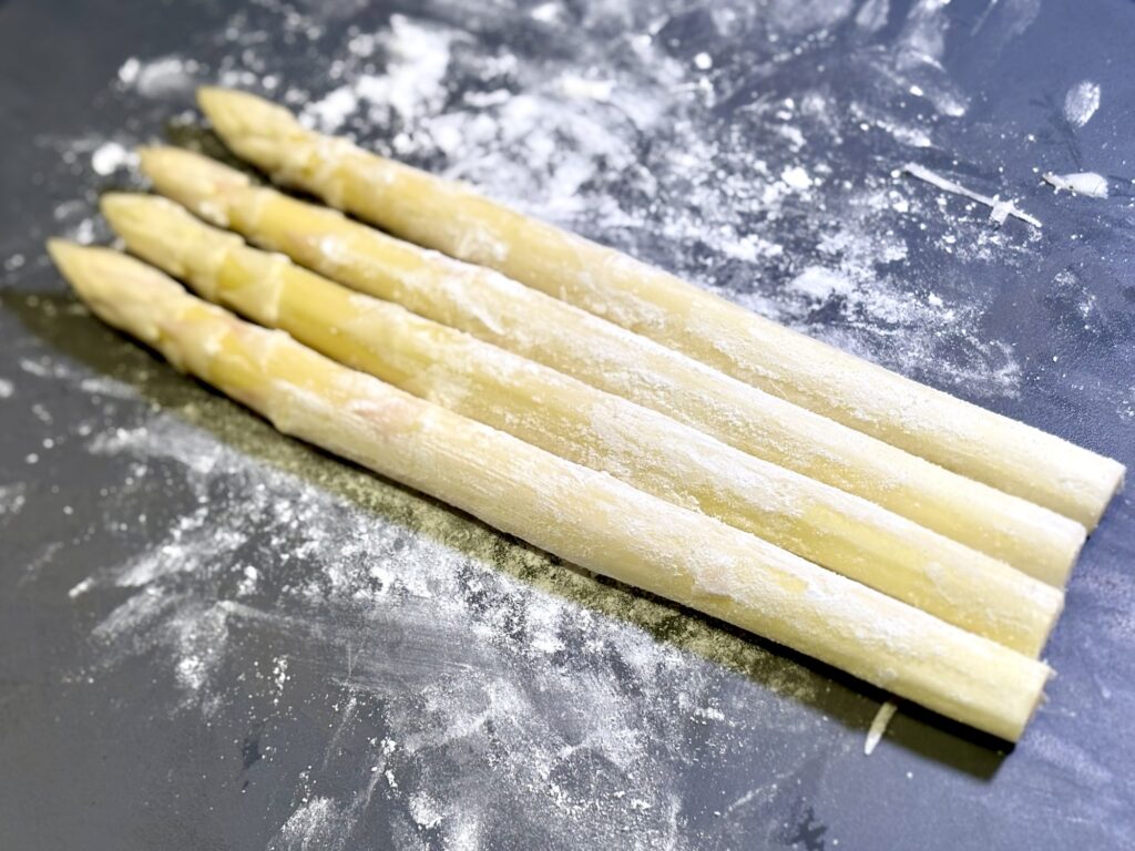 ホワイトアスパラに米粉をまぶしている工程写真
