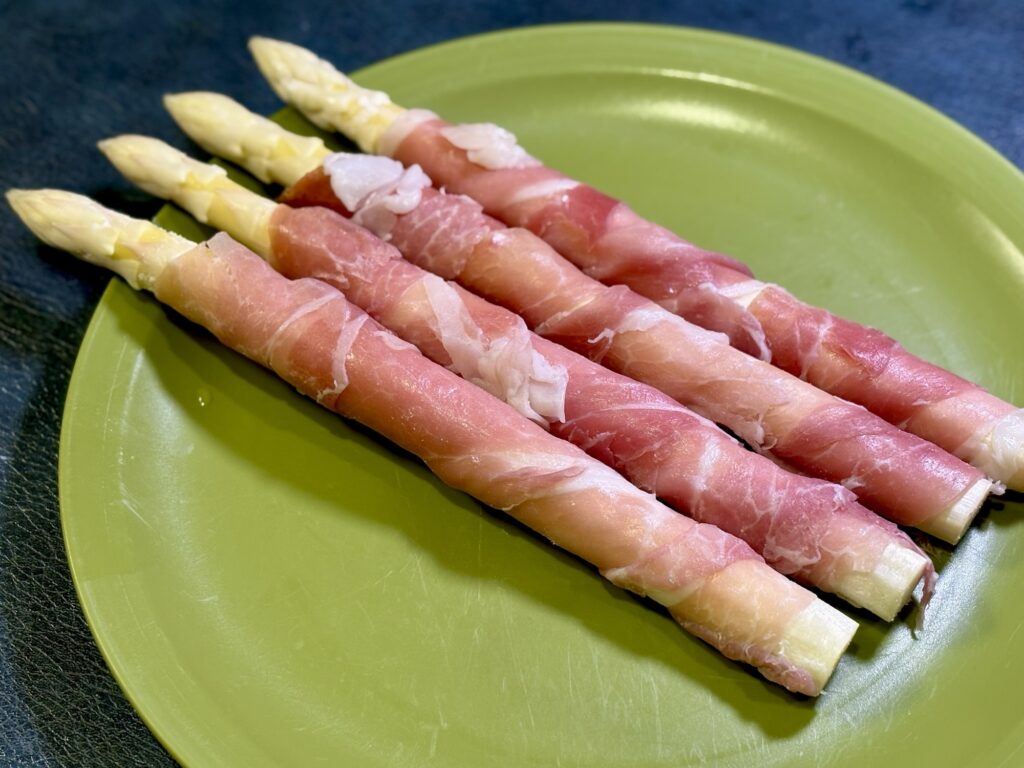 ホワイトアスパラに生ハムを巻いている工程写真