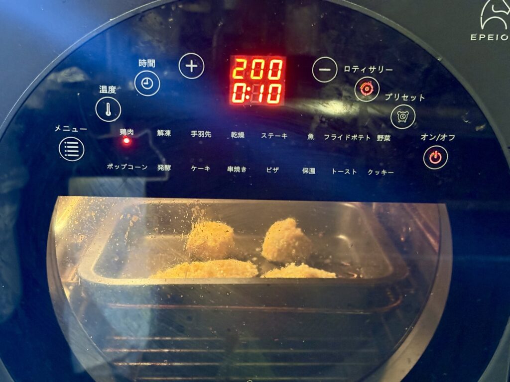 エペイオス・ノンフライオーブンで牡蠣フライとミートボールフライを200度10分で焼いている表示の写真