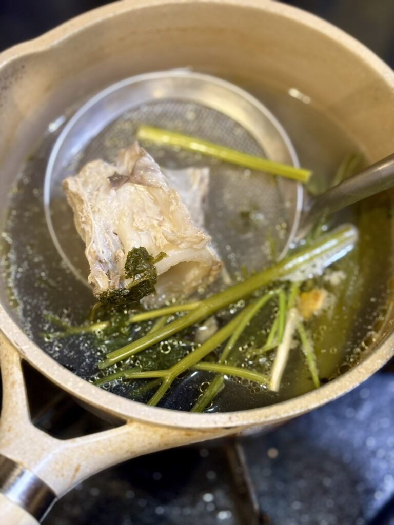 焼いたあとのマグロテールの骨と香味野菜で出汁を取っている鍋