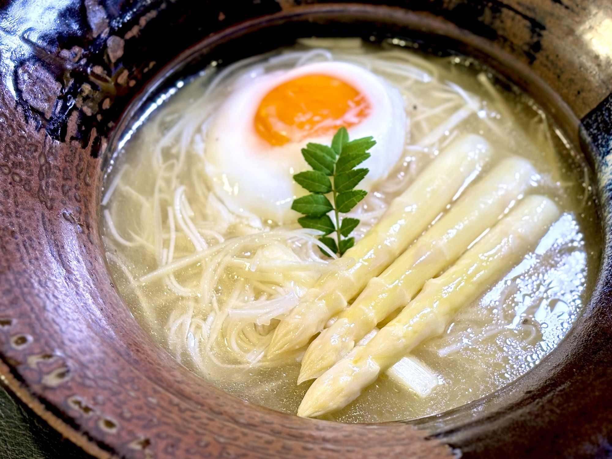 ホワイトアスパラの穂先と半熟卵と山椒の葉を添えた完成したにゅうめん