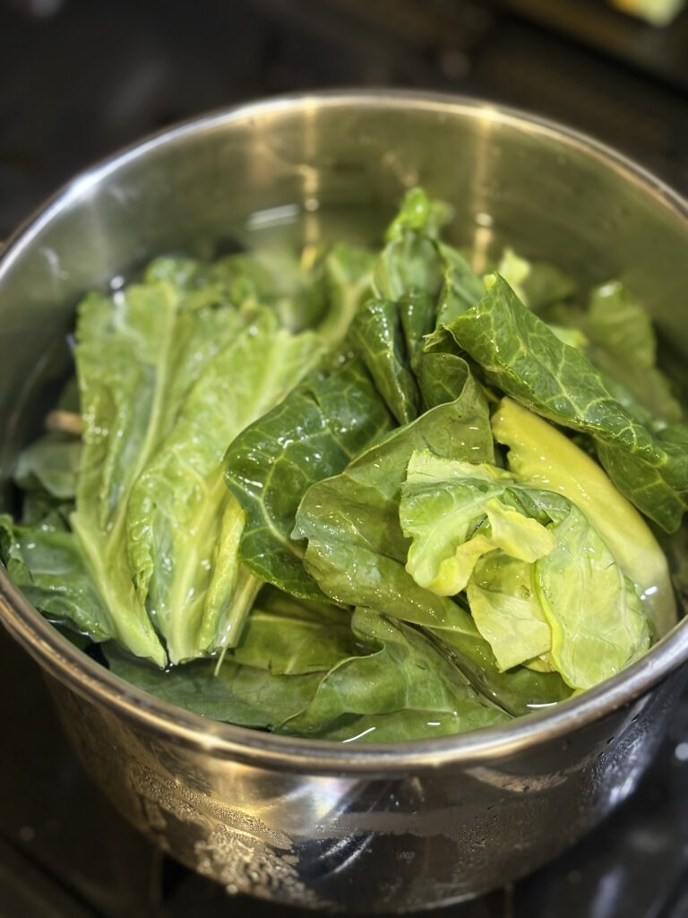 魚の骨の出汁に春キャベツの外葉を加えている様子