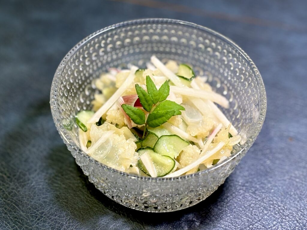 キャノンボールクラゲと塩もみ胡瓜を白い醤油麹からし胡麻だれで和え、新生姜と山椒の葉を添えた前菜