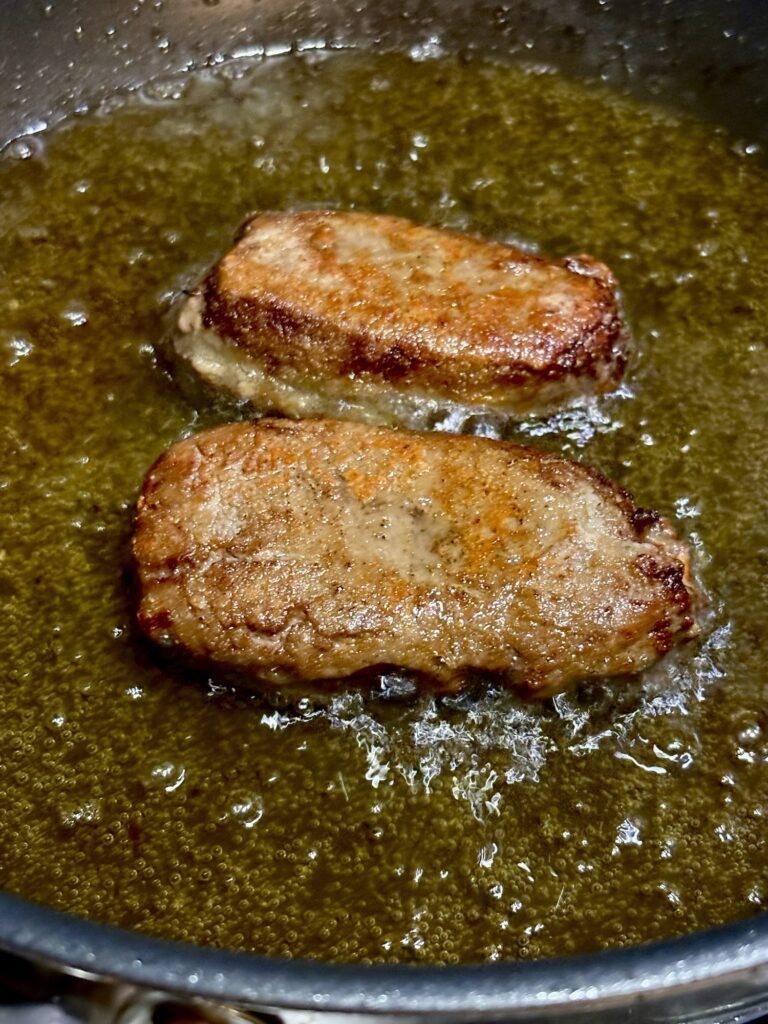 片栗粉をつけた豚レバーを油で香ばしく焼いている写真