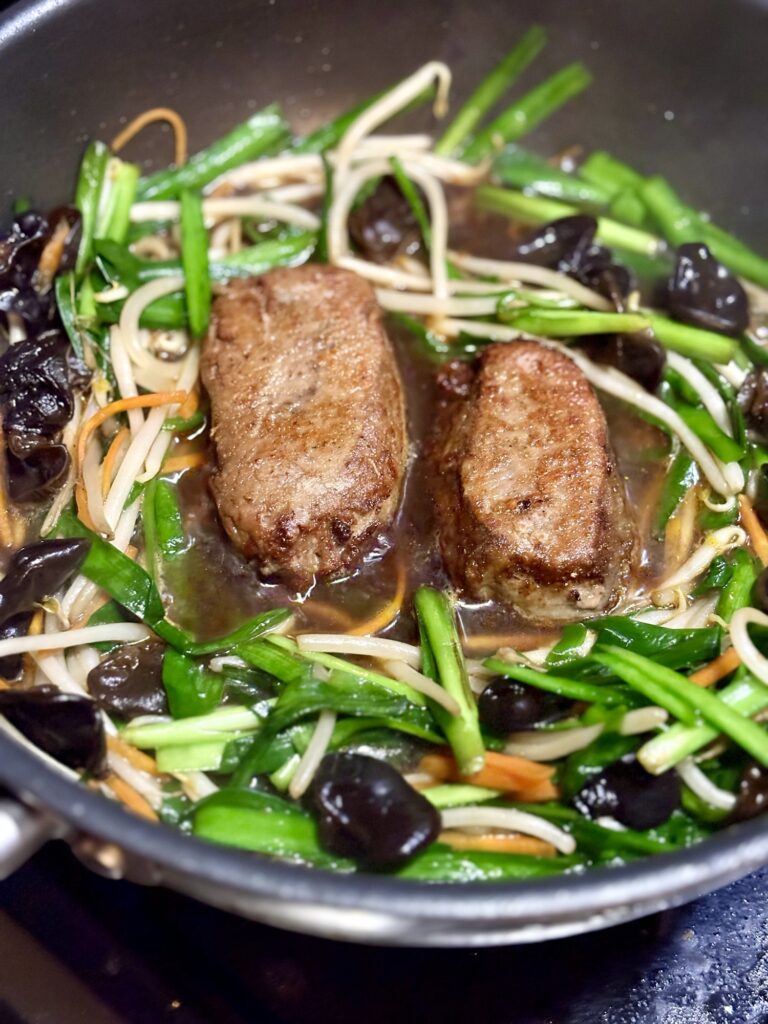 焼いた低温豚レバーをニラもやし炒めに戻して仕上げる写真