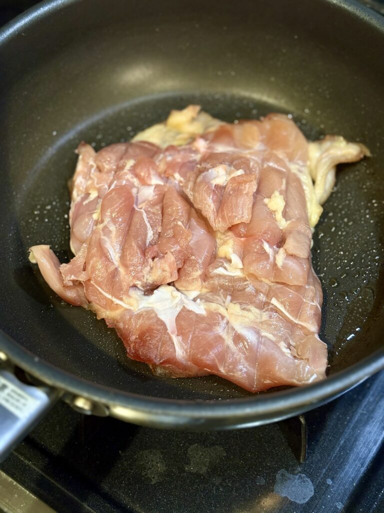 鶏もも肉を冷たいフライパンに皮目から入れて弱火で焼く様子